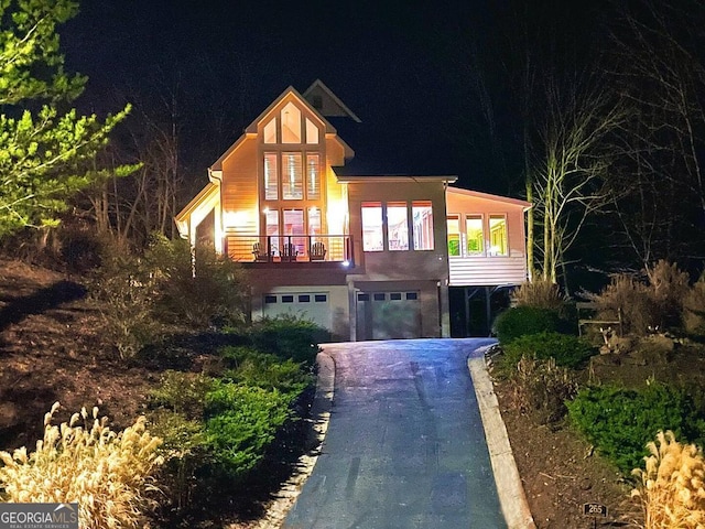view of front of property featuring a garage, driveway, and a balcony