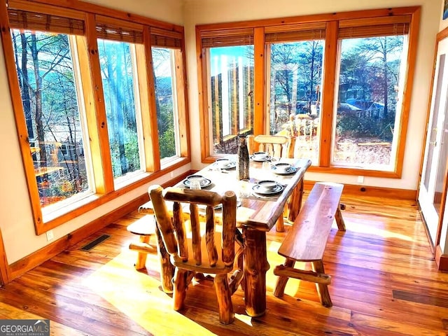 sunroom featuring baseboards and wood finished floors