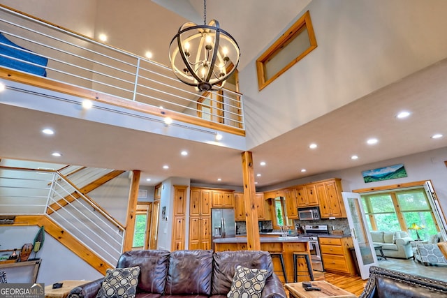living area with a chandelier, recessed lighting, and stairs