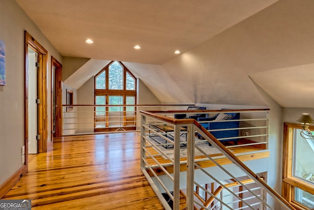 hallway featuring wood finished floors, lofted ceiling, an upstairs landing, and recessed lighting