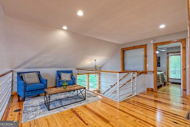 living area featuring wood finished floors, an upstairs landing, a chandelier, recessed lighting, and vaulted ceiling