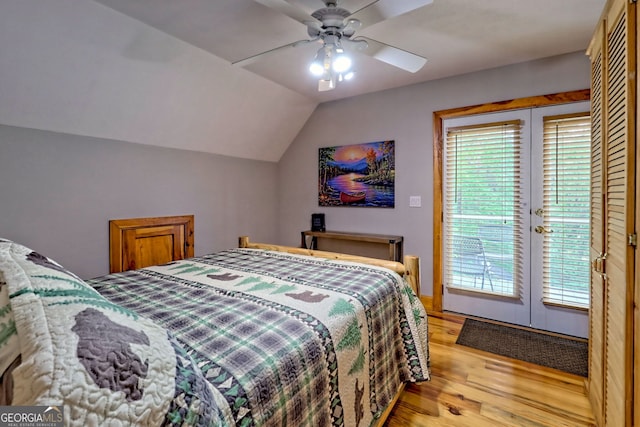 bedroom with light wood-style floors, access to outside, vaulted ceiling, and a ceiling fan