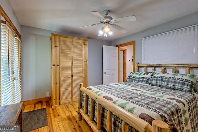bedroom featuring light wood-type flooring, a closet, baseboards, and a ceiling fan