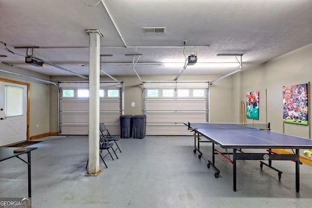 playroom featuring a garage, concrete floors, healthy amount of natural light, and a textured ceiling