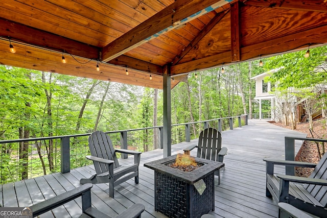 deck featuring an outdoor fire pit and a forest view