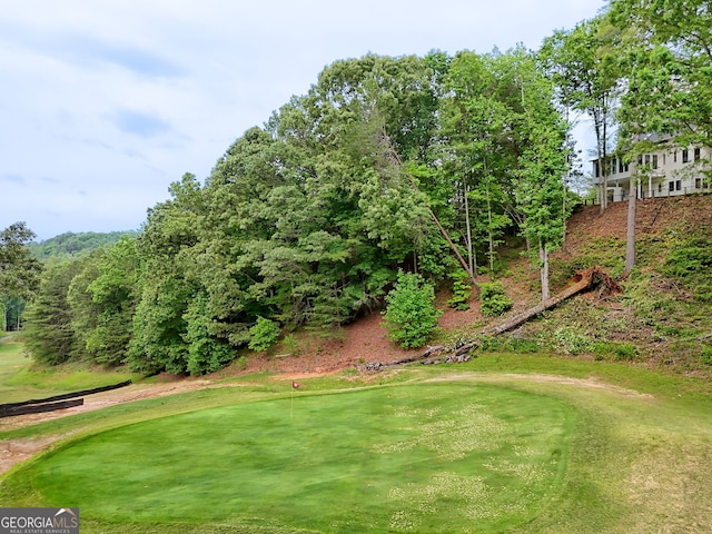 surrounding community featuring golf course view and a putting area