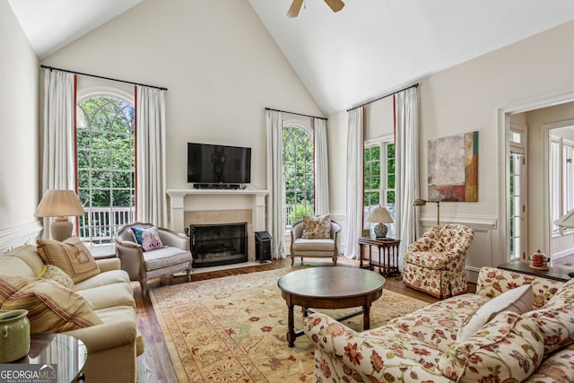 4070 Ridgehurst Dr SE, Smyrna, GA 30080 - living area featuring wood finished floors, high vaulted ceiling, a fireplace with flush hearth, healthy amount of natural light, and a ceiling fan