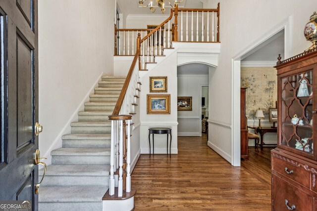 4070 Ridgehurst Dr SE, Smyrna, GA 30080 - foyer entrance featuring wood finished floors, stairs, arched walkways, a chandelier, and a towering ceiling