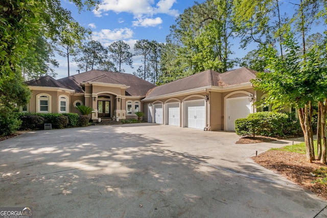 364 Osprey Cir, Saint Marys, GA 31558 - mediterranean / spanish home featuring french doors, stucco siding, an attached garage, and concrete driveway