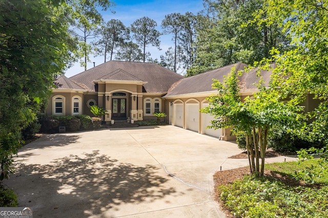 364 Osprey Cir, Saint Marys, GA 31558 - mediterranean / spanish home featuring french doors, stucco siding, a garage, and driveway