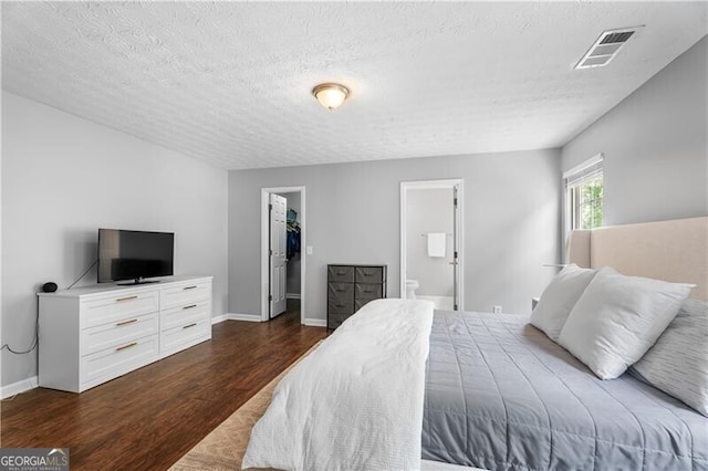 411 Sugar Maple Ct, Canton, GA 30114 - bedroom featuring dark wood finished floors, a textured ceiling, a spacious closet, ensuite bathroom, and baseboards