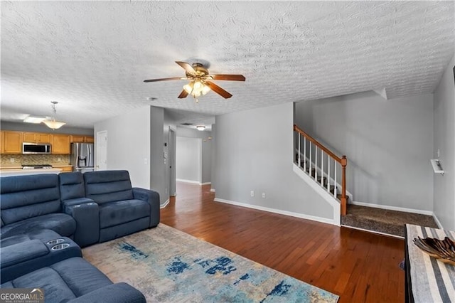 411 Sugar Maple Ct, Canton, GA 30114 - living room featuring wood finished floors, ceiling fan, baseboards, a textured ceiling, and stairs
