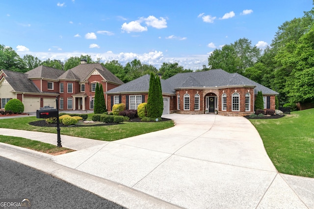 1610 Turtle Pond Dr, Hoschton, GA 30548 - colonial-style house with brick siding, a garage, concrete driveway, and a front lawn