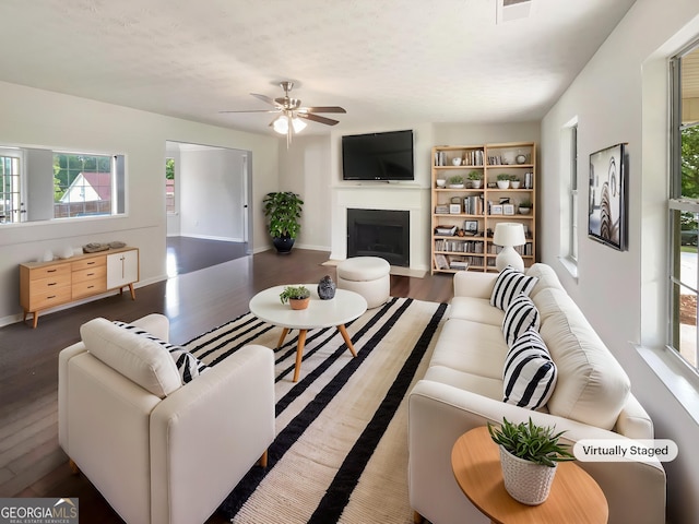727 Overlook Crst, Monroe, GA 30655 - living room with wood finished floors, healthy amount of natural light, a fireplace with flush hearth, and a ceiling fan