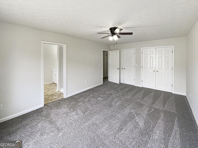 727 Overlook Crst, Monroe, GA 30655 - unfurnished bedroom with dark carpet, two closets, and ceiling fan
