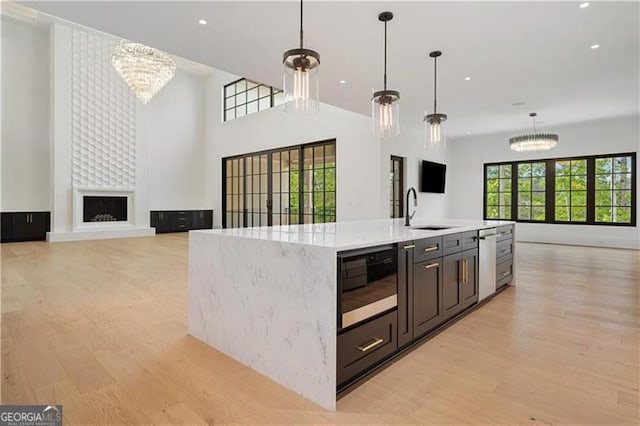 241 Traditions Dr, Alpharetta, GA 30004 - kitchen featuring a sink, open floor plan, light wood-style floors, a chandelier, and recessed lighting
