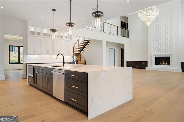 241 Traditions Dr, Alpharetta, GA 30004 - kitchen featuring a chandelier, stainless steel appliances, white cabinets, a towering ceiling, and light wood finished floors