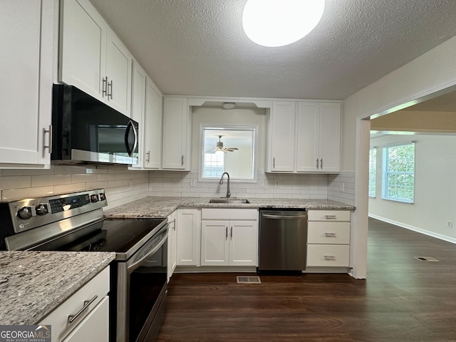 485 Angham Rd, Hiram, GA 30141 - kitchen with stainless steel appliances, dark wood-style flooring, white cabinets, backsplash, and a textured ceiling