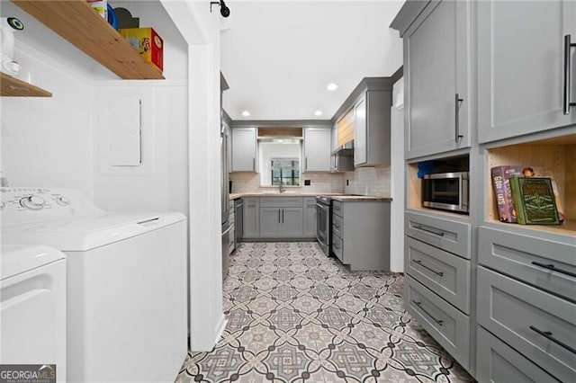 52 Chaumont Sq NW, Atlanta, GA 30327 - kitchen with gray cabinetry, stainless steel appliances, washer and dryer, backsplash, and light countertops
