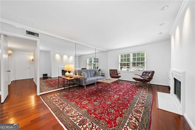 52 Chaumont Sq NW, Atlanta, GA 30327 - living room featuring a fireplace with flush hearth, wood finished floors, crown molding, and baseboards