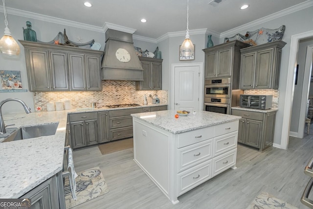 216 Jake Colton Dr, Kingsland, GA 31548 - kitchen with appliances with stainless steel finishes, a sink, premium range hood, backsplash, and light stone counters