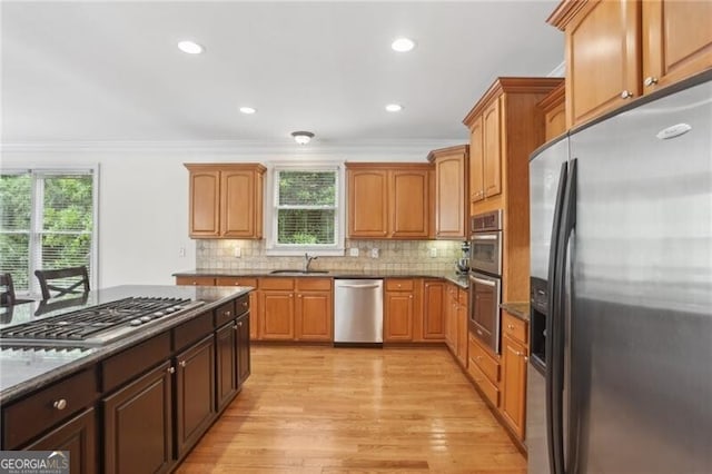 1029 Ector Dr NW, Kennesaw, GA 30152 - kitchen featuring appliances with stainless steel finishes, ornamental molding, light wood-type flooring, tasteful backsplash, and recessed lighting