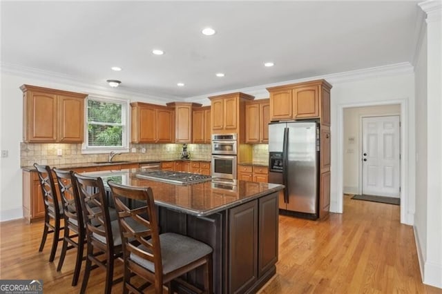 1029 Ector Dr NW, Kennesaw, GA 30152 - kitchen featuring stainless steel appliances, a sink, a kitchen island, crown molding, and a kitchen bar