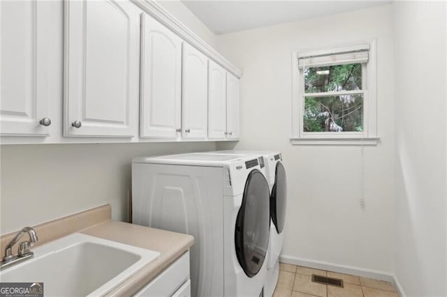 1029 Ector Dr NW, Kennesaw, GA 30152 - clothes washing area featuring cabinet space, washing machine and dryer, light tile patterned floors, and baseboards