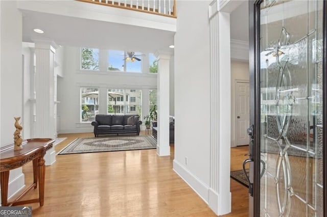1029 Ector Dr NW, Kennesaw, GA 30152 - foyer featuring ornate columns, a towering ceiling, ceiling fan, light wood-style floors, and baseboards