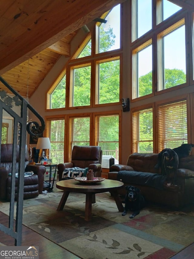 living room featuring high vaulted ceiling, beam ceiling, healthy amount of natural light, wood finished floors, and wooden ceiling
