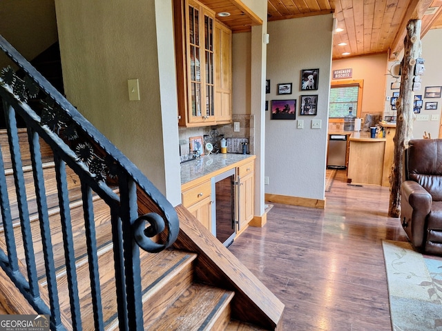 indoor bar featuring wood ceiling, beverage cooler, wood finished floors, stairs, and baseboards