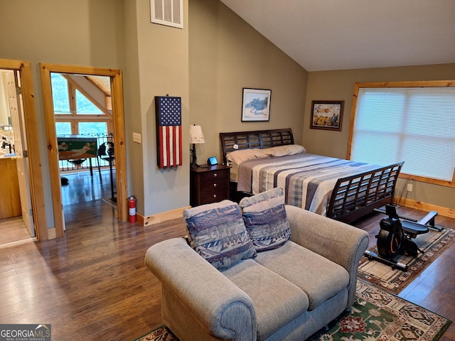bedroom with wood finished floors, baseboards, and high vaulted ceiling