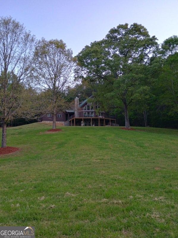 view of green lawn featuring a deck