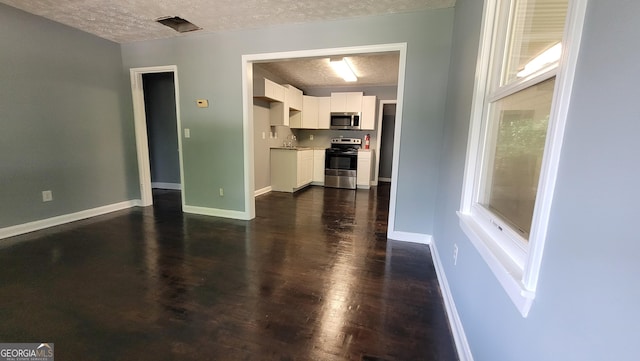 214 Upshaw St SW, Atlanta, GA 30315 - kitchen featuring appliances with stainless steel finishes, a textured ceiling, white cabinetry, a sink, and dark wood-style floors