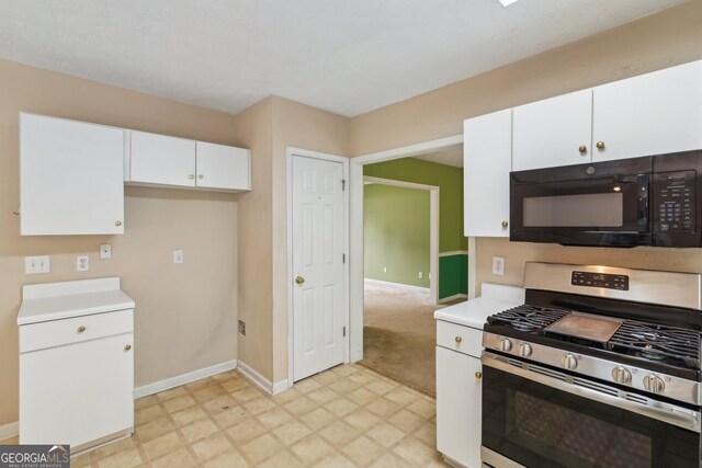 111 Trellis Ct, Acworth, GA 30101 - kitchen with gas stove, black microwave, white cabinetry, and baseboards