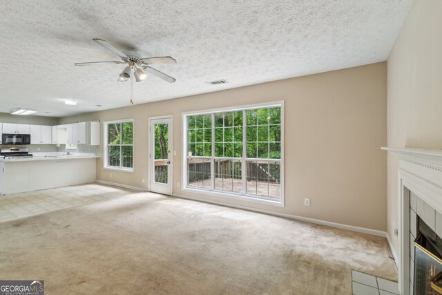 111 Trellis Ct, Acworth, GA 30101 - unfurnished living room featuring carpet, ceiling fan, baseboards, a textured ceiling, and a fireplace