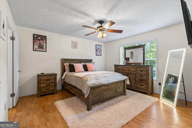 1154 Pinebrook Rd, Auburn, GA 30011 - bedroom with light wood-style flooring, baseboards, ceiling fan, and a textured ceiling