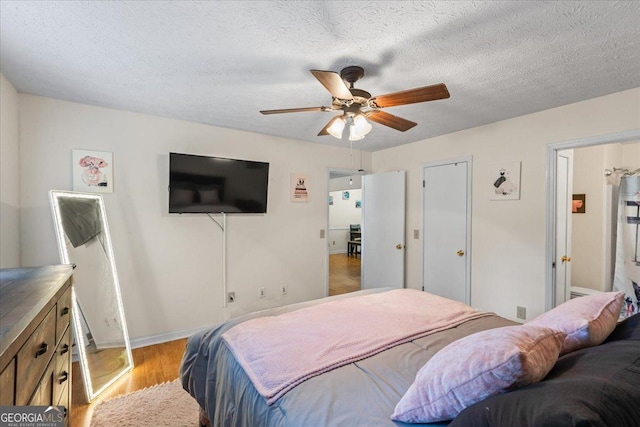 1154 Pinebrook Rd, Auburn, GA 30011 - bedroom featuring light wood-type flooring, baseboards, ceiling fan, and a textured ceiling