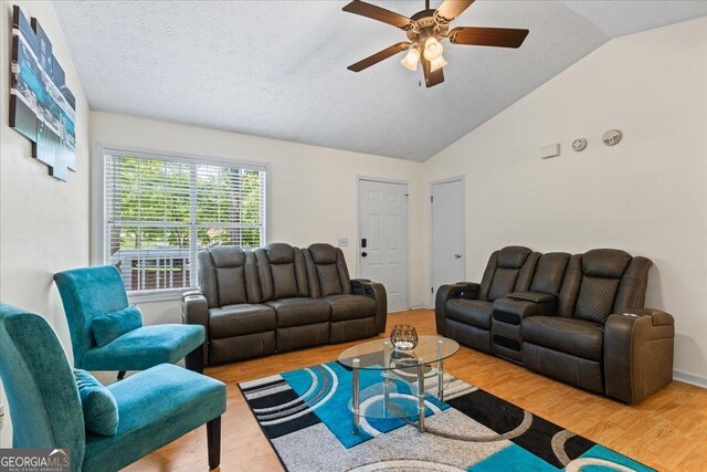 1154 Pinebrook Rd, Auburn, GA 30011 - living area featuring wood finished floors, ceiling fan, lofted ceiling, and a textured ceiling