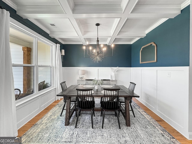 35 Perkins Cv, Senoia, GA 30276 - dining space with coffered ceiling, a chandelier, wood finished floors, beam ceiling, and crown molding