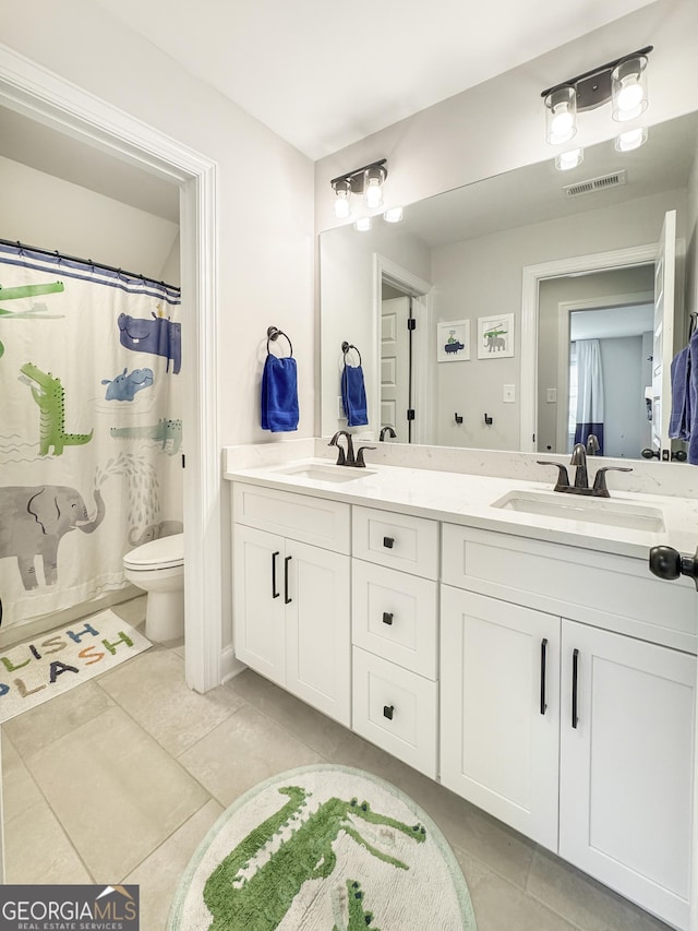 35 Perkins Cv, Senoia, GA 30276 - full bath featuring tile patterned floors, toilet, double vanity, and a shower with shower curtain
