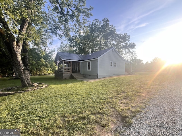 view of property exterior featuring crawl space, a yard, and metal roof