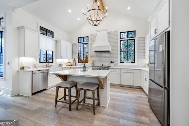 201 Dobbs Rd, Woodstock, GA 30188 - kitchen with stainless steel appliances, custom exhaust hood, a kitchen island, backsplash, and a chandelier