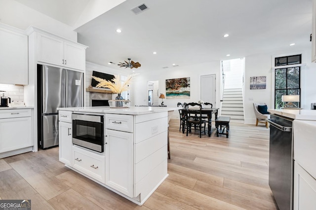 201 Dobbs Rd, Woodstock, GA 30188 - kitchen with appliances with stainless steel finishes, recessed lighting, white cabinetry, light countertops, and light wood-style floors