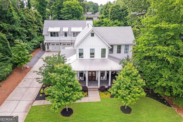 201 Dobbs Rd, Woodstock, GA 30188 - view of front of home featuring board and batten siding, concrete driveway, covered porch, a chimney, and a front lawn