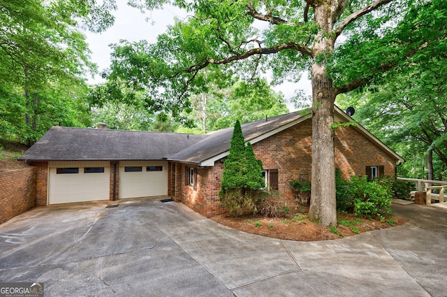 view of front of property featuring brick siding, driveway, an attached garage, and roof with shingles