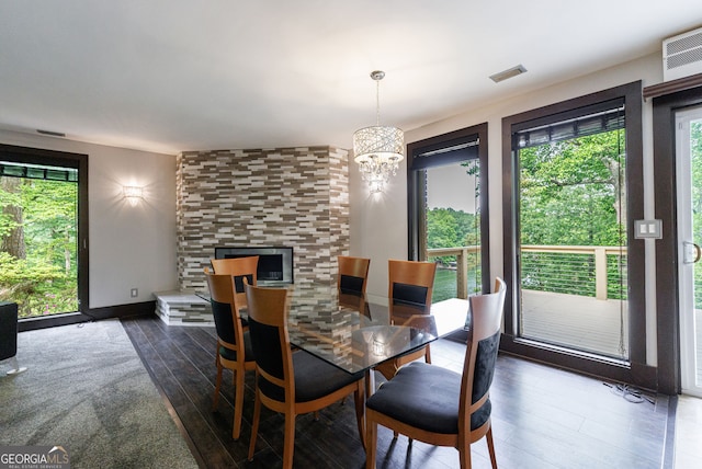 dining area featuring plenty of natural light, dark wood-type flooring, and a chandelier