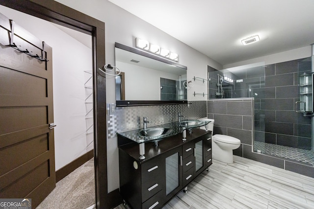 full bathroom with toilet, a shower stall, and double vanity