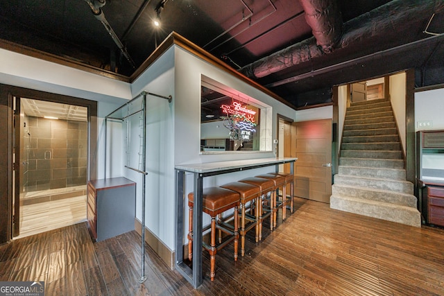 stairs with track lighting and wood finished floors