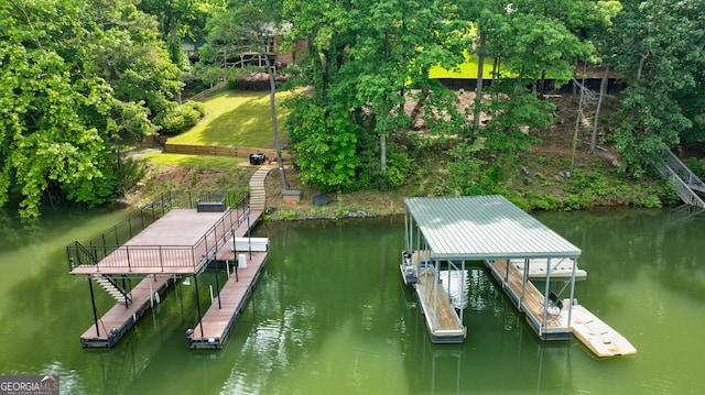 dock featuring a water view, boat lift, stairs, and view of wooded area